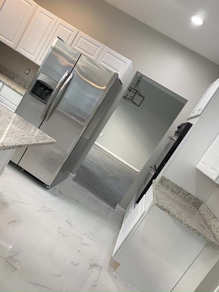 An image of a spotless kitchen area with a fridge 